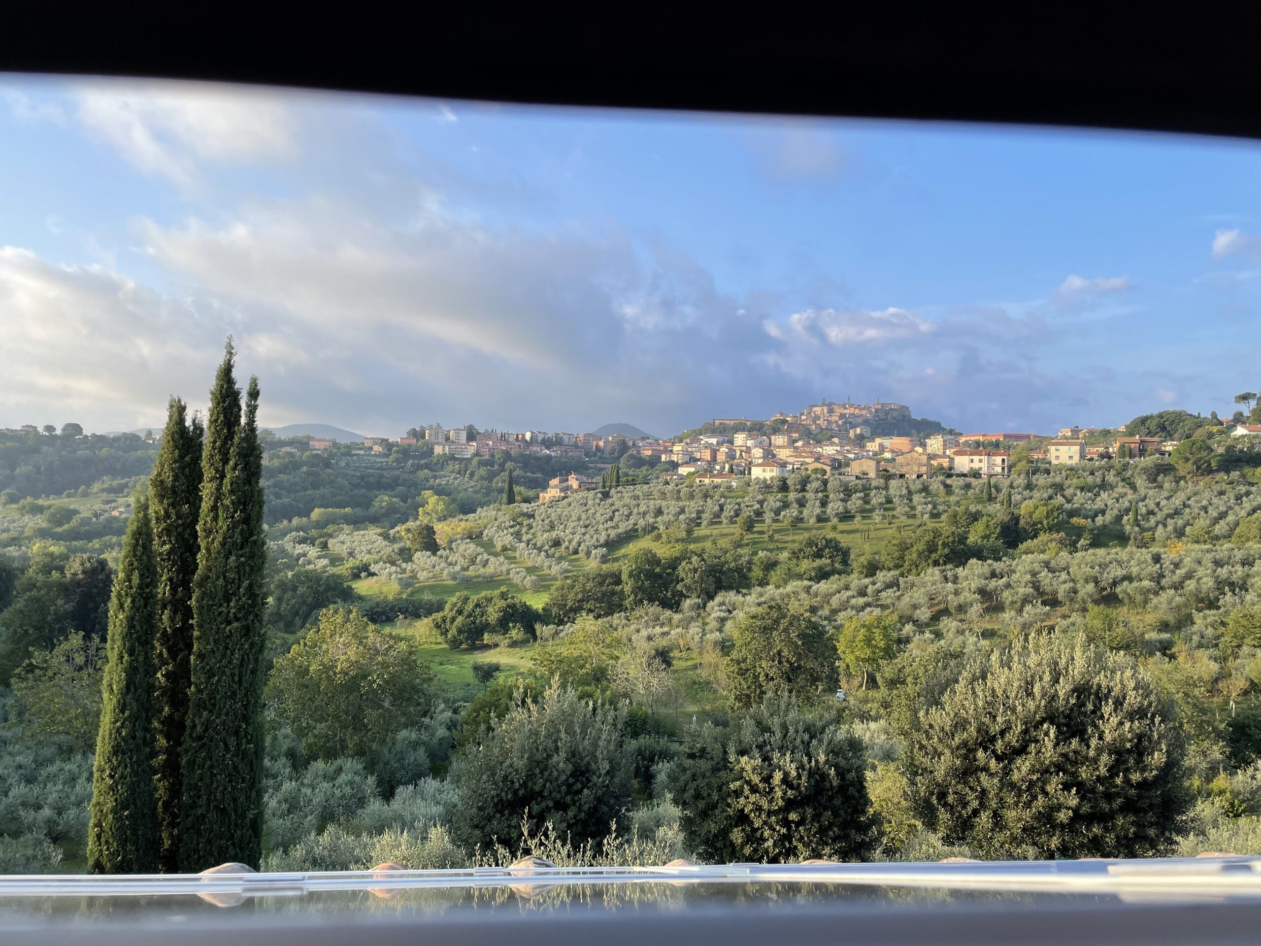 Blick aus einem Fenster in die grüne Landschaft der Toskana
